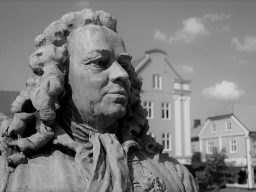 Närbild av en staty föreställande en man med stor peruk i Alingsås
