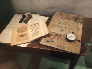 Historiska föremål på ett bord – sigill, böcker och ett fickur